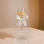 Ποτήρι με λουλούδια και λευκή κορδέλα